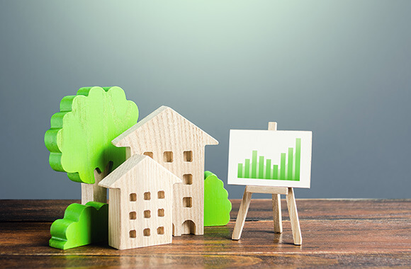 木製の家と木製の木、金利を表すグラフをイメージしたイメージ画像