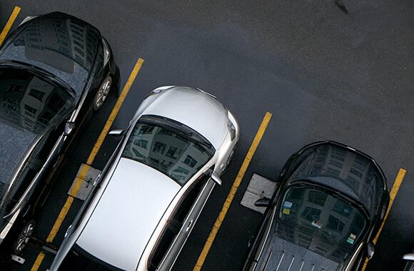 車が止まっている駐車場にロードヒーティング設備がある様子をイメージしたイメージ画像