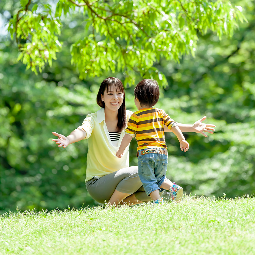 30代の母親と3歳前後の子供が公園で遊ぶ様子